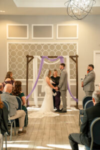 Indoor family wedding ceremony in Orlando with child joining the couple officiated by Once Upon 2 Rings